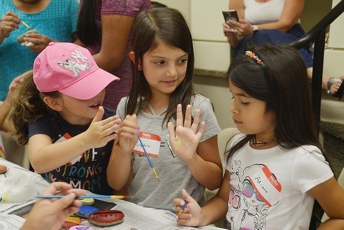Madison McConnell (left), Sophia Alonzi and Ariana Casarella compare exactly how many rocks they were able to paint at the library. The friends are excited to be in the same Park Avenue Elementary School second-grade class in a few weeks. 