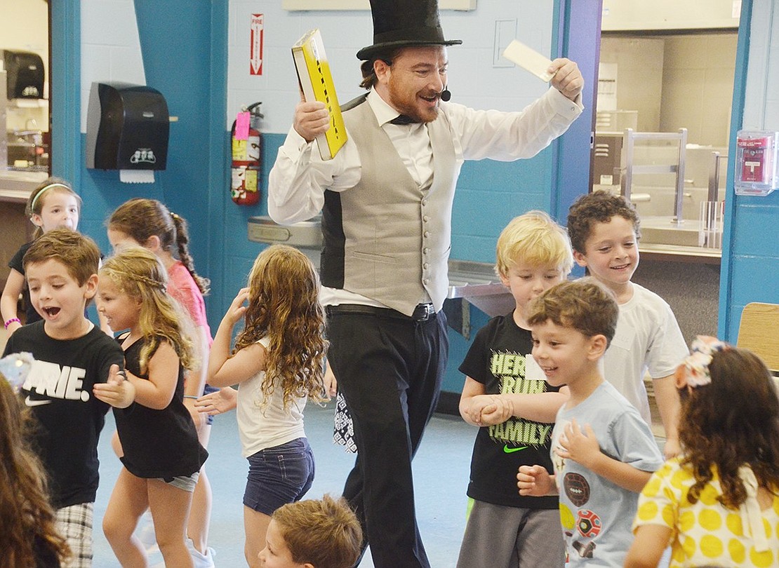 Unable to contain their excitement over The Great Charlini’s (Charles Hallock) tricks, several incoming Ridge Street Elementary School kindergarteners rush the stage during the Blind Brook PTA-sponsored Kindergarten Social at the elementary school on Tuesday, Aug. 28.