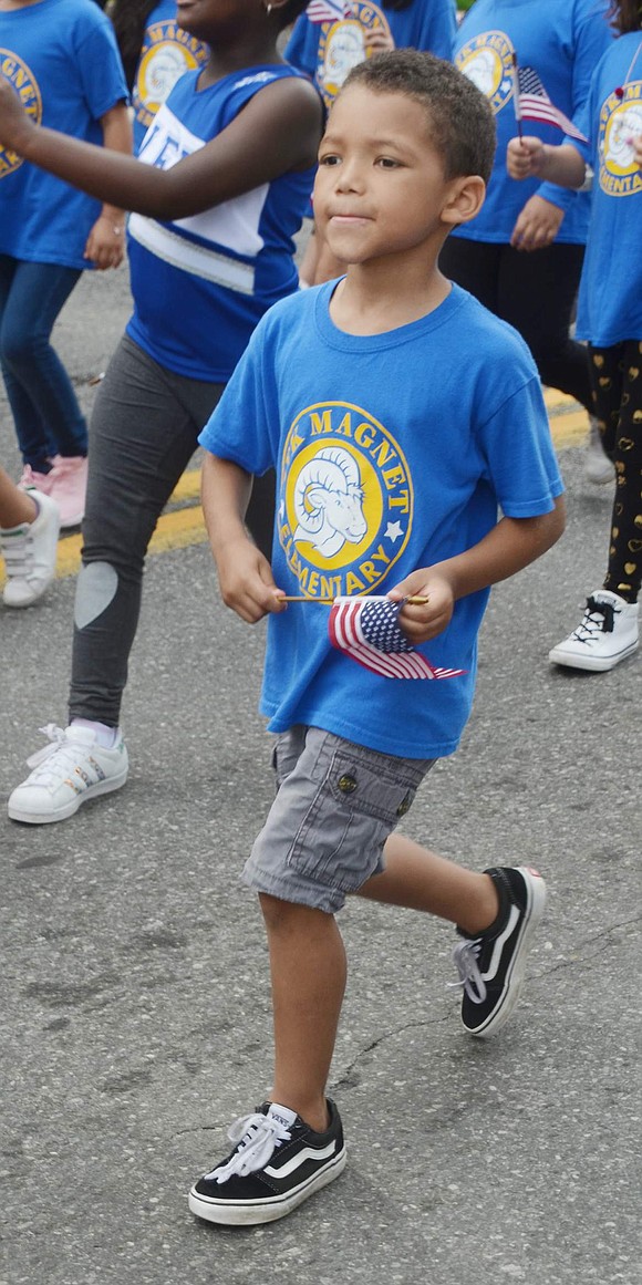 John F. Kennedy Elementary School first-grader Aiden Sammon shows school pride and national pride as he sports his blue school shirt and waves the American flag.