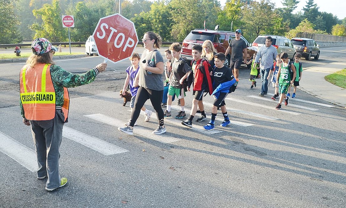 Crossing guard and Rye Brook resident Linda Kochanowicz holds her stop sign high at the Rockinghorse Trail and North Ridge Street intersection to help more than a dozen kids and parents get to Ridge Street Elementary School safely during International Walk to School Day on Wednesday, Oct. 10.