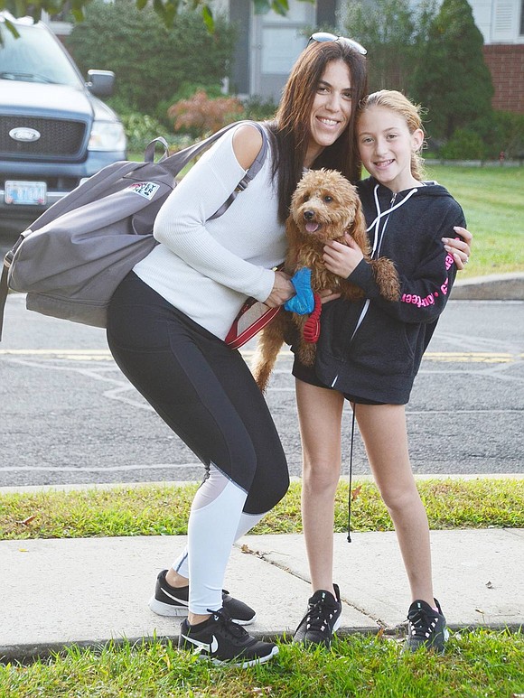 Walk to School Day promotes fitness, and dogs enjoy physical activity, too! Fourth-grader Ella and her mom Robin Hoberman pose for a picture with their rambunctious mini goldendoodle Rocky after walking all the way from Little Kings Lane.