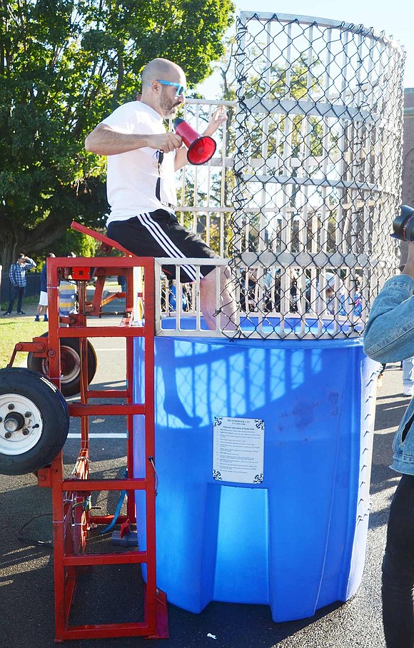 The joking, merciless mocking must of have worked, as one of High School Band Director Mike Miceli’s students hits the bullseye causing him to slide into the dunk tank at the second annual Port Chester High School Carnival.