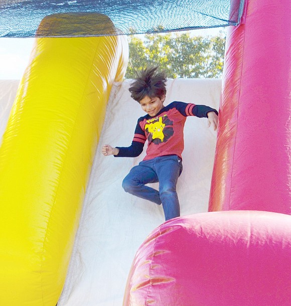 White Plains resident Vijay Jadav’s hair goes wild as he bounces down the inflatable obstacle course slide. The third-grader is enjoying the carnival with his mother Virginia Peterson, a high school computer science teacher.