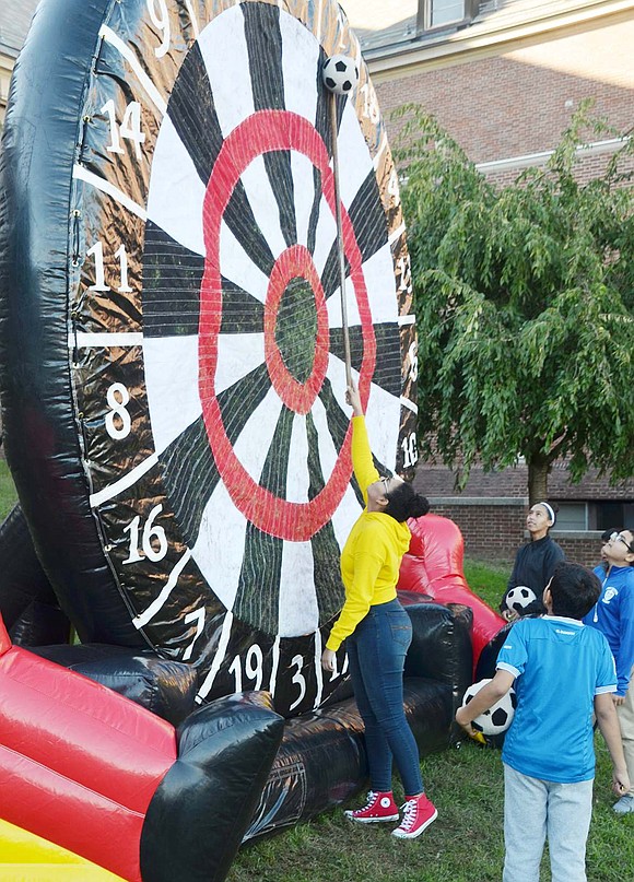 Karly Thomas, the volunteer manning the Soccer Kick Challenge, struggles to knock down a ball that struck the top of the giant scoreboard. The Roanoke Avenue resident is a senior at Port Chester High School.