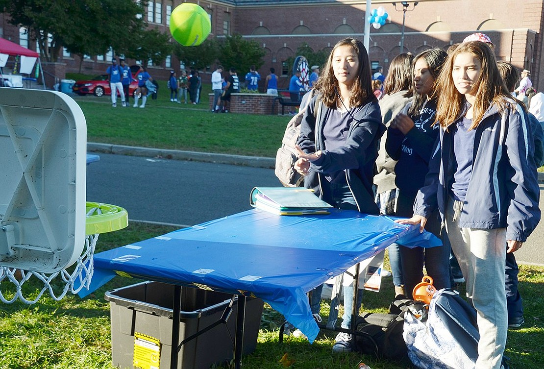 As sophomore Lea Maxwell (left) tosses a ball at the hoop, her friends Alexandra Vega and Callie Schultz, also sophomores, closely watch to see if it’s going in.