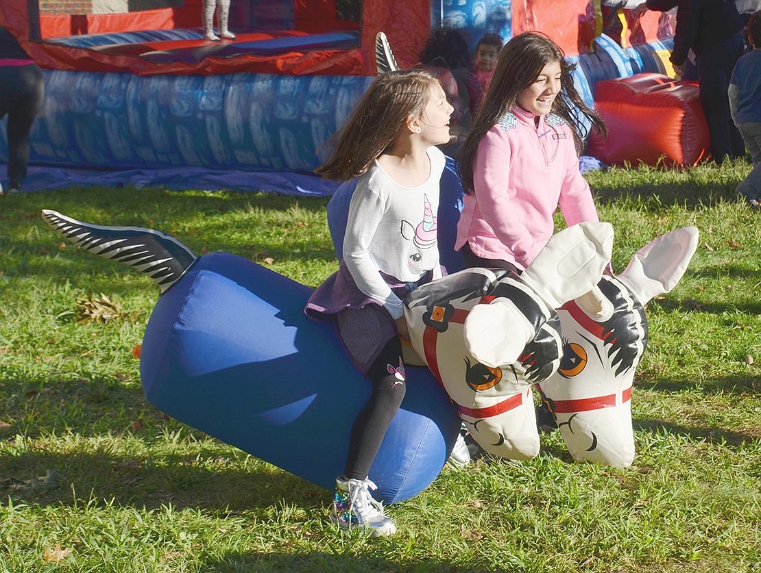 While bouncing on inflatable horses, Park Avenue second-graders Sophia Alonzi (left) and Jacqueline Villa spring to the finish line in the horse race game.