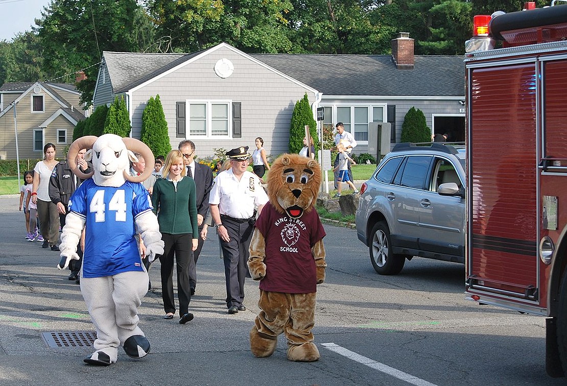 Rammy, the Port Chester High School mascot, played by alumnae Gianna Villanova, now a PCHS student, and Roary the King Street School mascot, played by alumnus Noah Rotfeld, now also a student at PCHS, lead a parade of officials, students and teachers around the King Street School driveway to give all pupils, even those who arrived by bus or otherwise couldn’t walk to school, some exercise. This workout followed a ceremony in which local, county and state officials presented proclamations and made remarks about the benefits of walking to school.