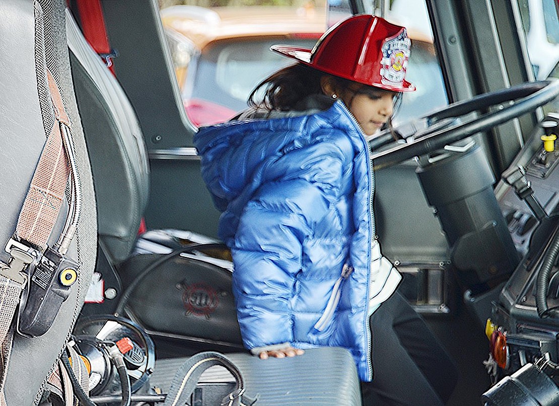 Sporting a Rye Brook Fire Department plastic hat, second-grader Amiya Kothari makes sure to check out what it’s like to sit in the fire engine driver’s seat before heading home.