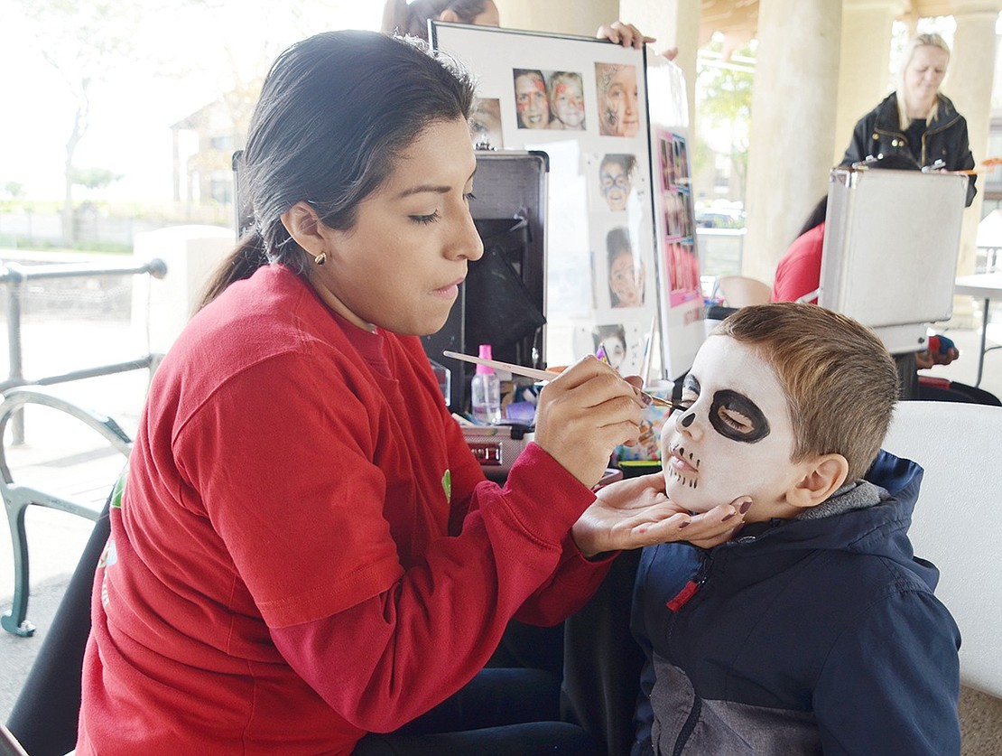 New Rochelle resident Vuk Vlajkovic, 3, is starting to look very spooky as Port Chester resident Linda Torres makes his face look like a skeleton. Torres painted dozens of kids’ faces during the festival representing her father’s Port Chester-based business Lobetito Show.