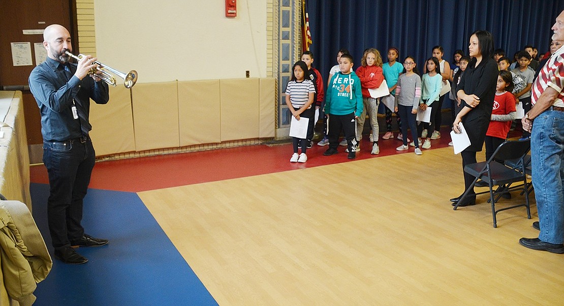 As attendees in the gymnasium stand, Mike Miceli plays “Taps” on the trumpet during the Park Avenue Elementary School Veterans Day ceremony on Friday, Nov. 9. Prior to the event, the Port Chester High School Band director also played “Taps” at the King Street Elementary School Veterans Day ceremony.