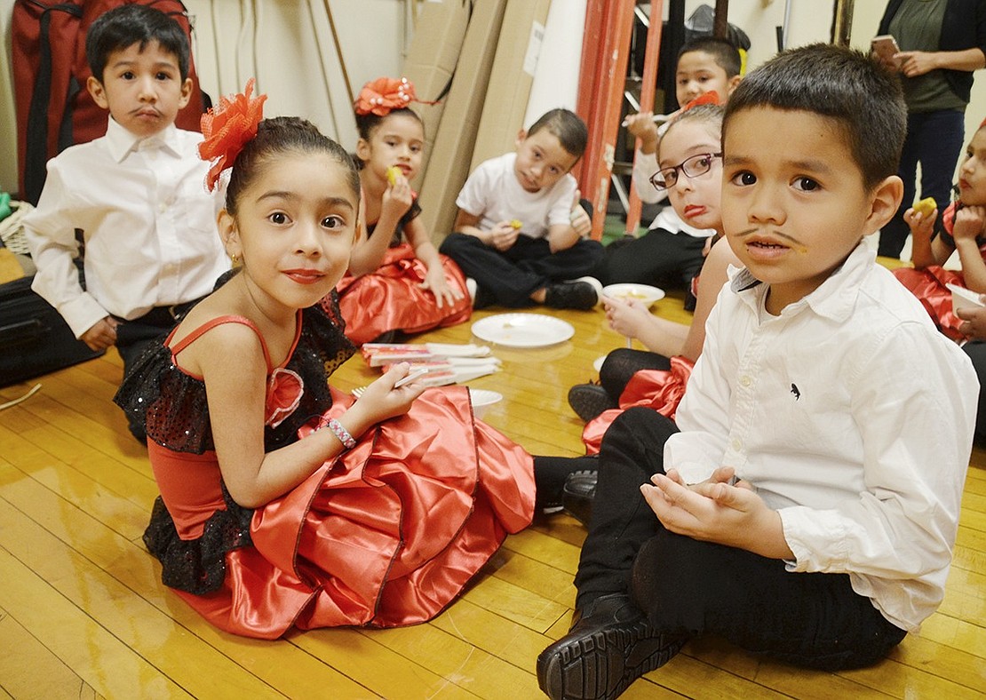 In Spanish-themed clothing and drawn-on mustaches, Jhesuar Guirola (left), Mia Romero and Erick Navas sit with their classmates backstage to eat dinner before their performance on Monday, Nov. 19. The Edison Elementary School kindergarteners are preparing to do a bullfighting-inspired dance for the school’s annual Cultural Celebration which featured a variety of performances and potluck dinner. Sarah Wolpoff|Westmore News 