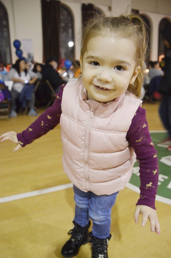 Dalilah Chavez, a 2-year-old enjoying the evening with her family, takes a brief break from dancing around the gymnasium to smile for the camera. Sarah Wolpoff|Westmore News 