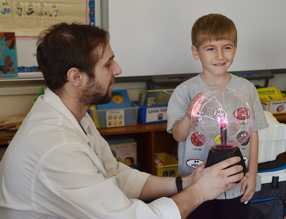 High Touch High Tech Scientist Brad Line brings out the plasma dome after teaching the kids about lightning, and Ethan Berg is surprised with how warm it feels.