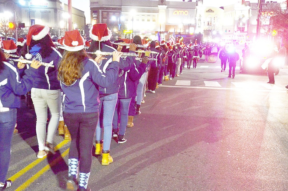 Port Chester High School Marching Band flautists raise their instruments to play holiday tunes as they march down Abendroth Avenue during the Port Chester Downtown Christmas Parade and tree lighting on Tuesday, Dec. 4. It’s been decades since the village has hosted a downtown holiday parade, and officials hope this kicks off an annual tradition.