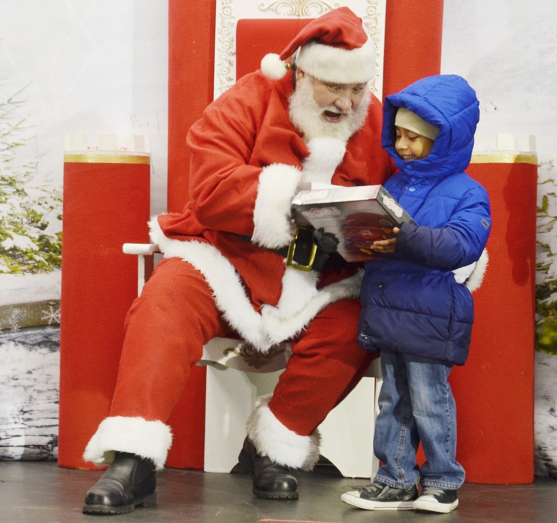 Edison Elementary School kindergartener Ruben Mosso is eager to show Santa Claus his new Cars edition of the board game Trouble. Charlie Sacco, playing Kris Kringle, is just as excited to check it out with him.