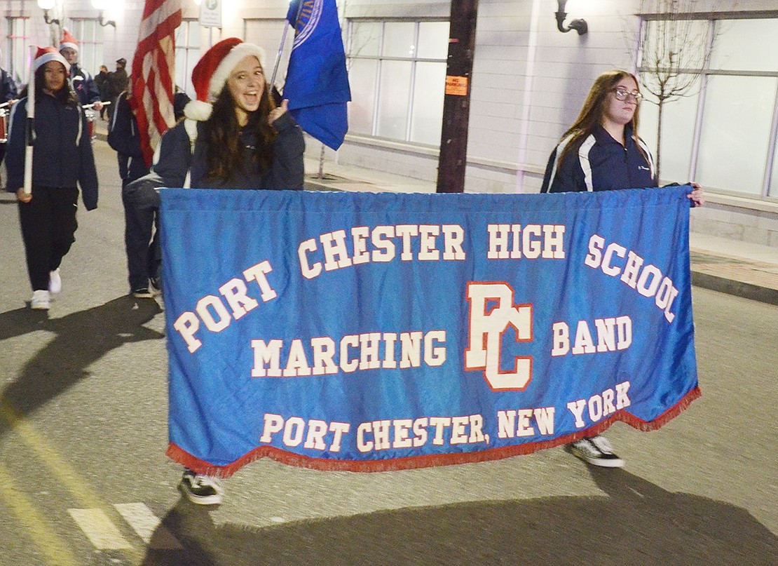 Port Chester High School sophomore Ava Quartarolo (left) gives a cheery thumbs up while carrying the banner with Jane Dominguez, also a sophomore, to lead the Pride of Port Chester down Abendroth Avenue.