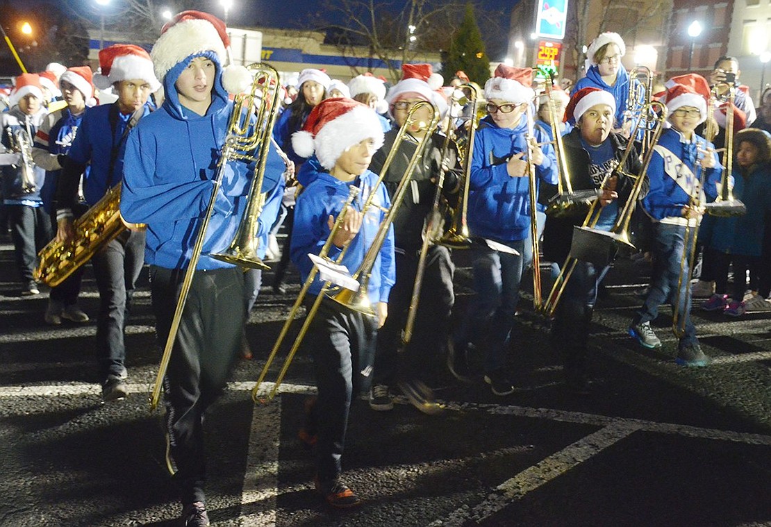 Trombonists in the Port Chester Middle School band file into the parking lot at the corner of Westchester and Abendroth avenues, the holiday procession’s destination.