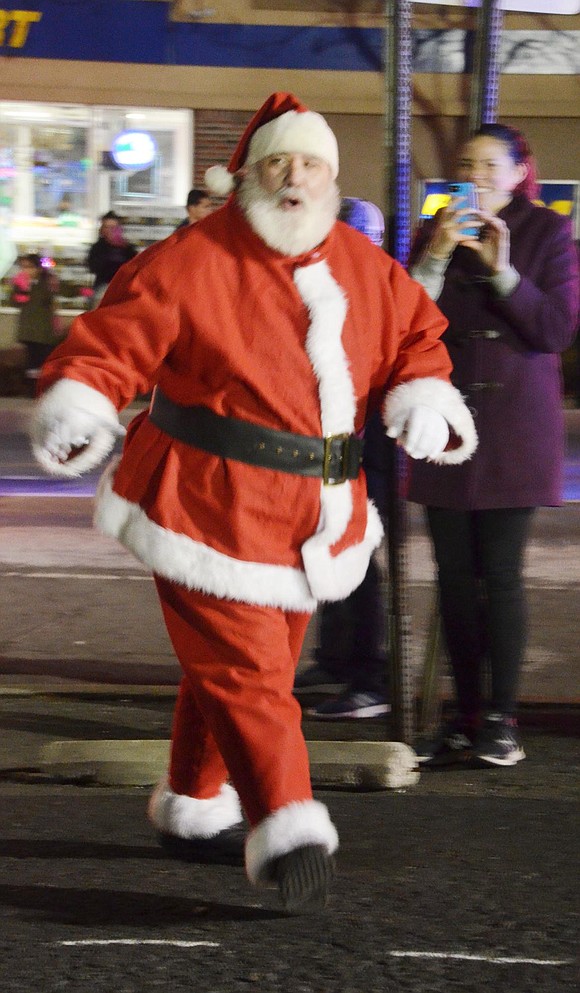 Dozens of children can be heard yelling “Santa!” as Charlie Sacco, dressed as Saint Nick, makes a grand entrance on a fire truck and walks to the stage to personally meet kids.