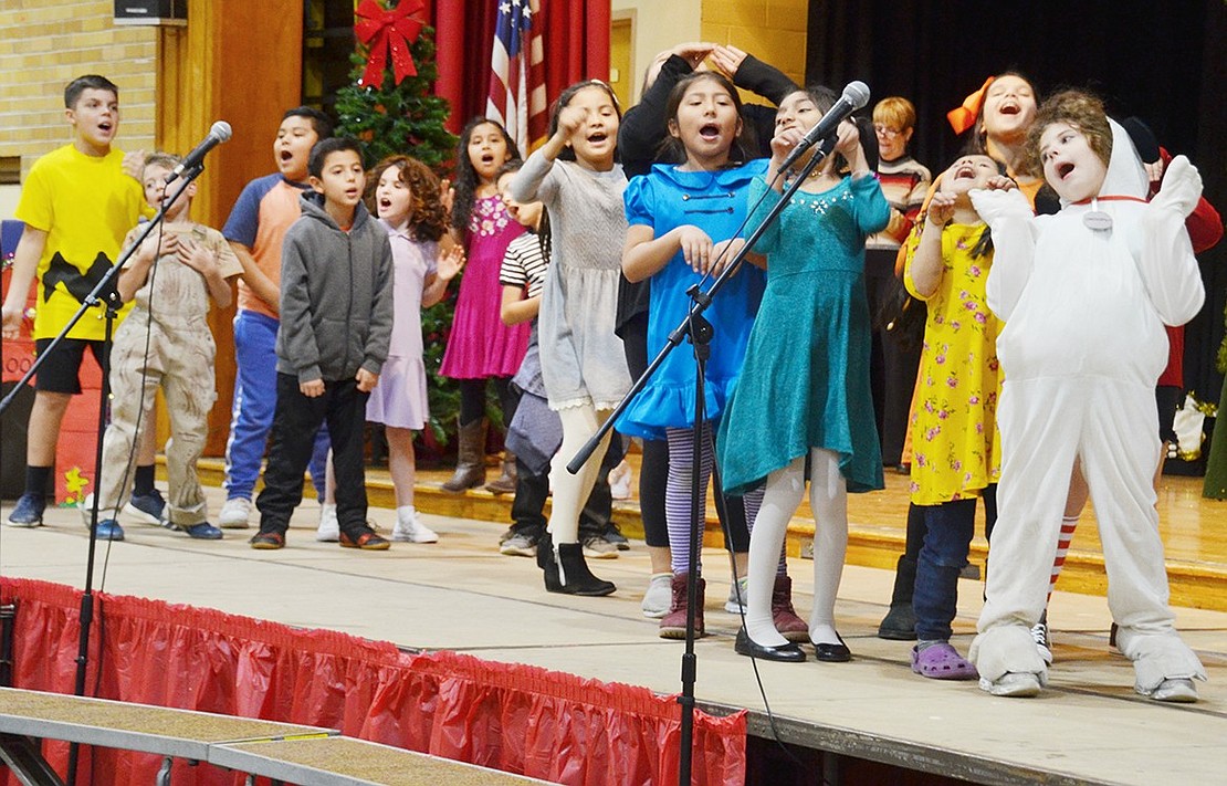 Students in the Saint John Bosco Parish religious education program act like they’re on a wild sleigh ride together while singing a jazzy interpretation of “Jingle Bells” during “A Charlie Brown Christmas” rehearsal in the Corpus Christi-Holy Rosary School gym. The show will be performed for an audience at 7 p.m. Saturday, Dec. 15, with a suggested $2 donation per ticket.