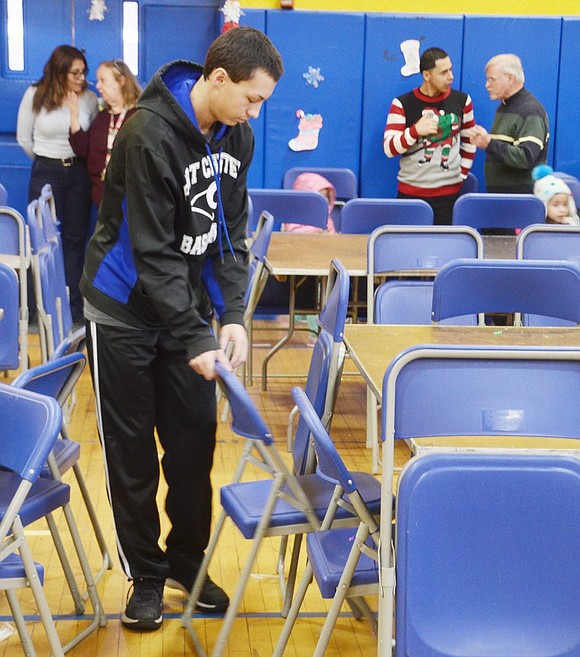 Volunteering for the morning with the Port Chester High School Key Club, junior Corey Heckel folds up chairs after visitors are finished with breakfast.