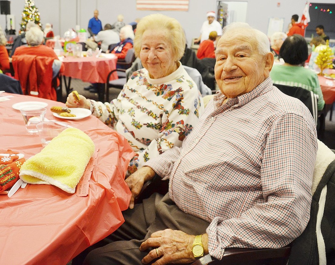 Monroe Place resident Frank Bellantoni and his wife Carmella relax and enjoy Christmas cookies together at the party.