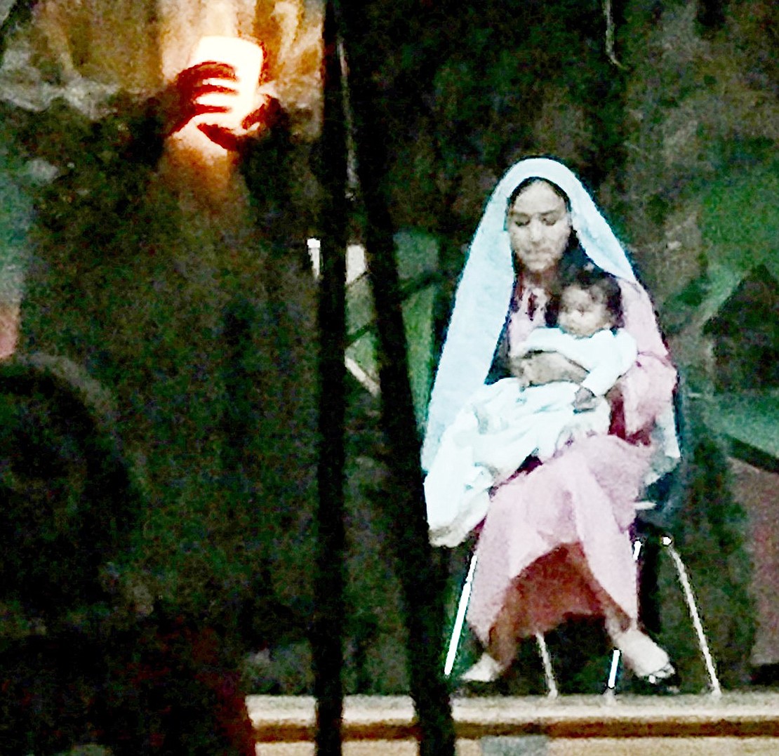 When the lights go out, Mary (played by Sophia Borda) cuddles baby Jesus (played by Katarina Nelson) by candlelight during the Corpus Christi-Holy Rosary School annual Christmas show on Friday, Dec. 14. This year’s show, “An Unplugged Christmas,” revealed how a group of kids discovered Christmas when the lights went out as they were preparing for a local Christmas show contest. Courtesy of Kathy Zaccagnino 