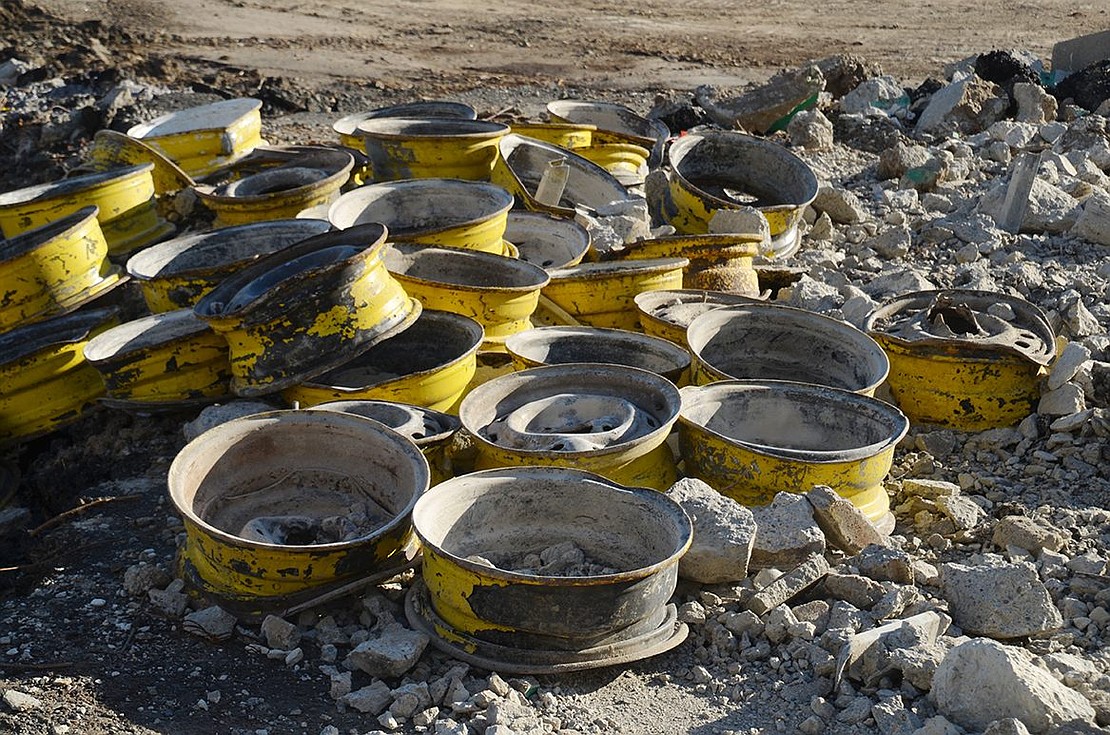 A pile of old truck wheel rims on the DPW site.