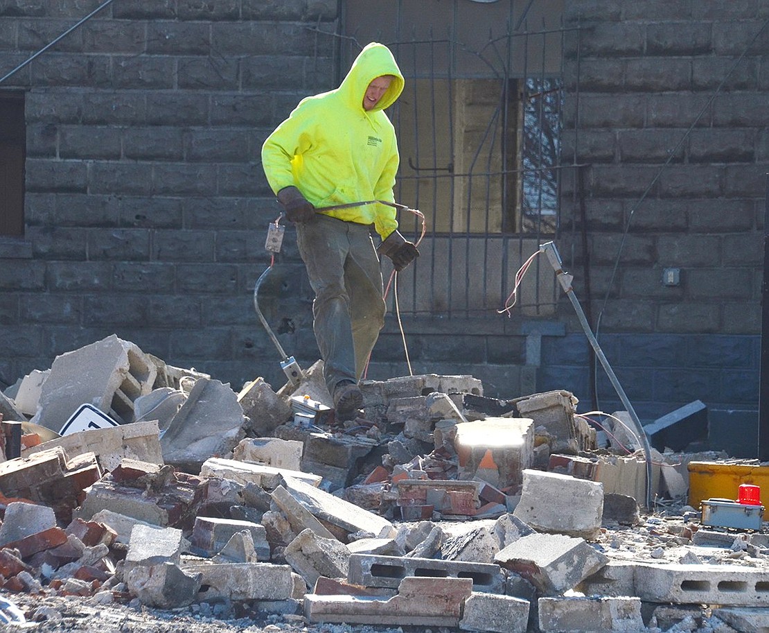 One man on the job from Tom Buske & Son Construction separates electrical cable from bricks during the demolition process. He operated four different pieces of equipment and admitted “I really could use another guy.”