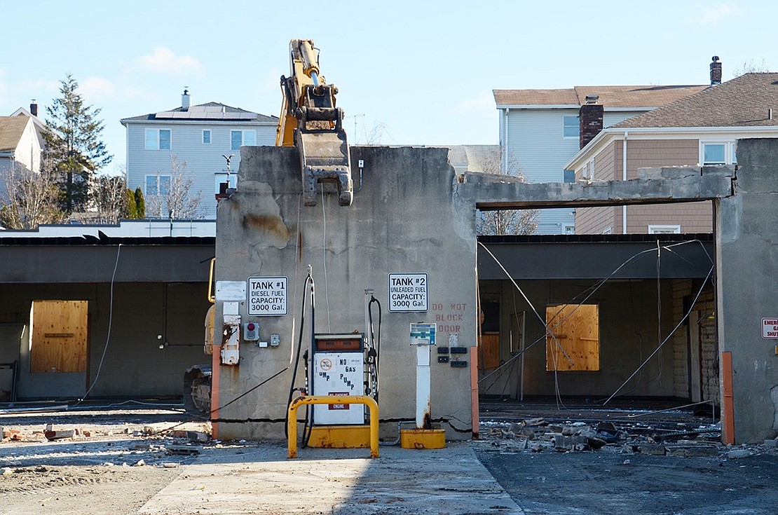 Excavator attempts to eat concrete wall of the building added in the 1950s.