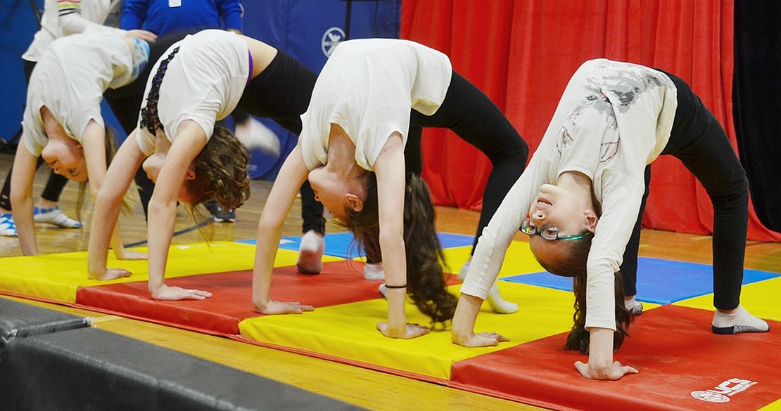 A group of acrobatically talented students line up in bridge poses to create a tunnel that they’ll crawl through one by one during their performance at the annual fourth-grade Blue Bird Circus at Ridge Street Elementary School on Friday, Dec. 14.