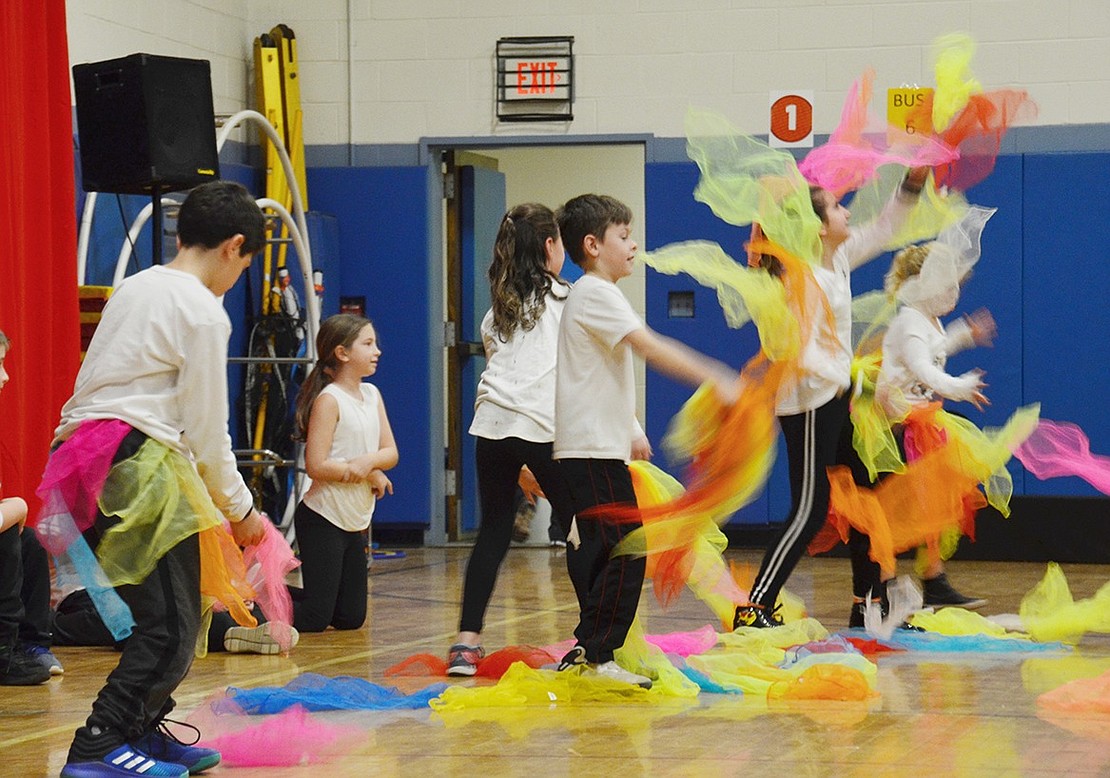 After a group of fourth-grader run on stage with colorful tutus, they rip the sheer fabric off, throw them in their air and laugh as they attempt to juggle bunches of the color swarms.