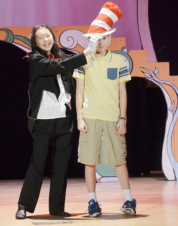 The Cat in the Hat, played by Lauren Sun, places her hat on Jojo, played by Tyler Oppenheimer, to give him the reins of creativity for the story.