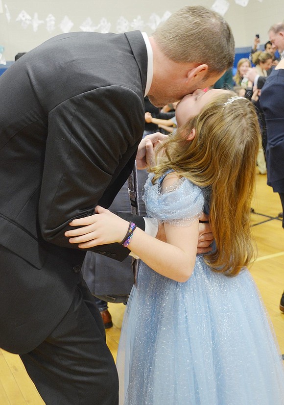 Dressed like a princess, Lela Samchalk gives her Prince Charming, otherwise known as her father Ross, a kiss on the cheek.