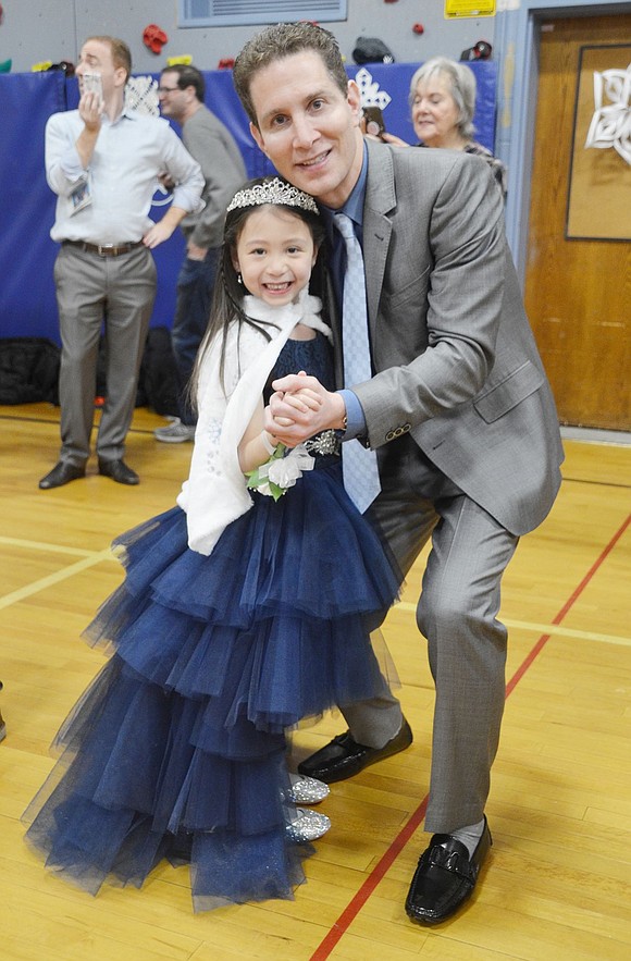 With her tiara and extravagant navy blue gown, Rachel Gordon looks like royalty as she dances with her dad, James.