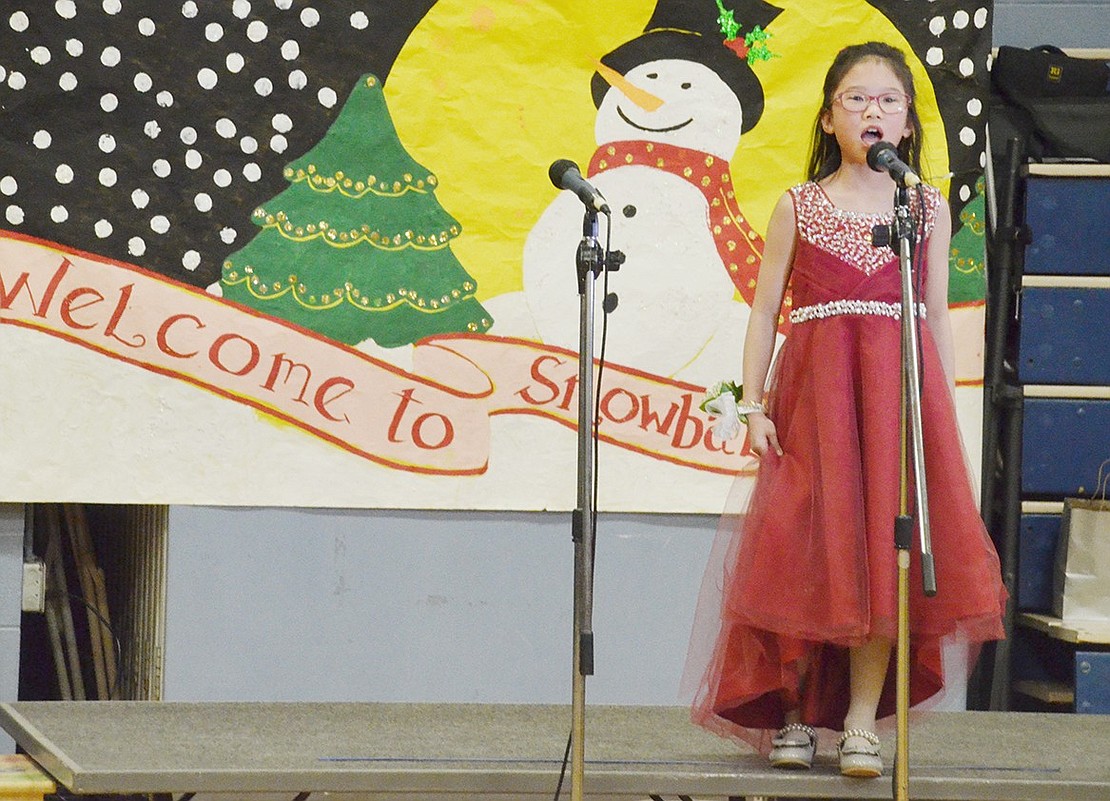 Third-grader Maggie Miao gets the Snowball festivities started with a boisterous delivery of the National Anthem.