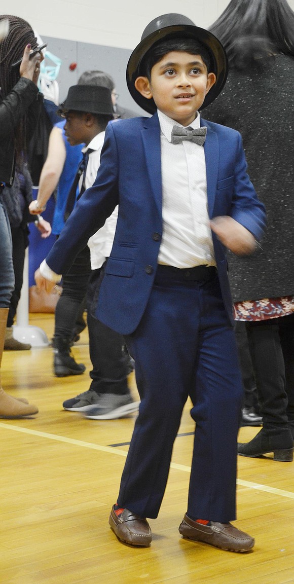 Aiden Faruque gets funky in his blue suit, bowtie and top hat as he does the twist.