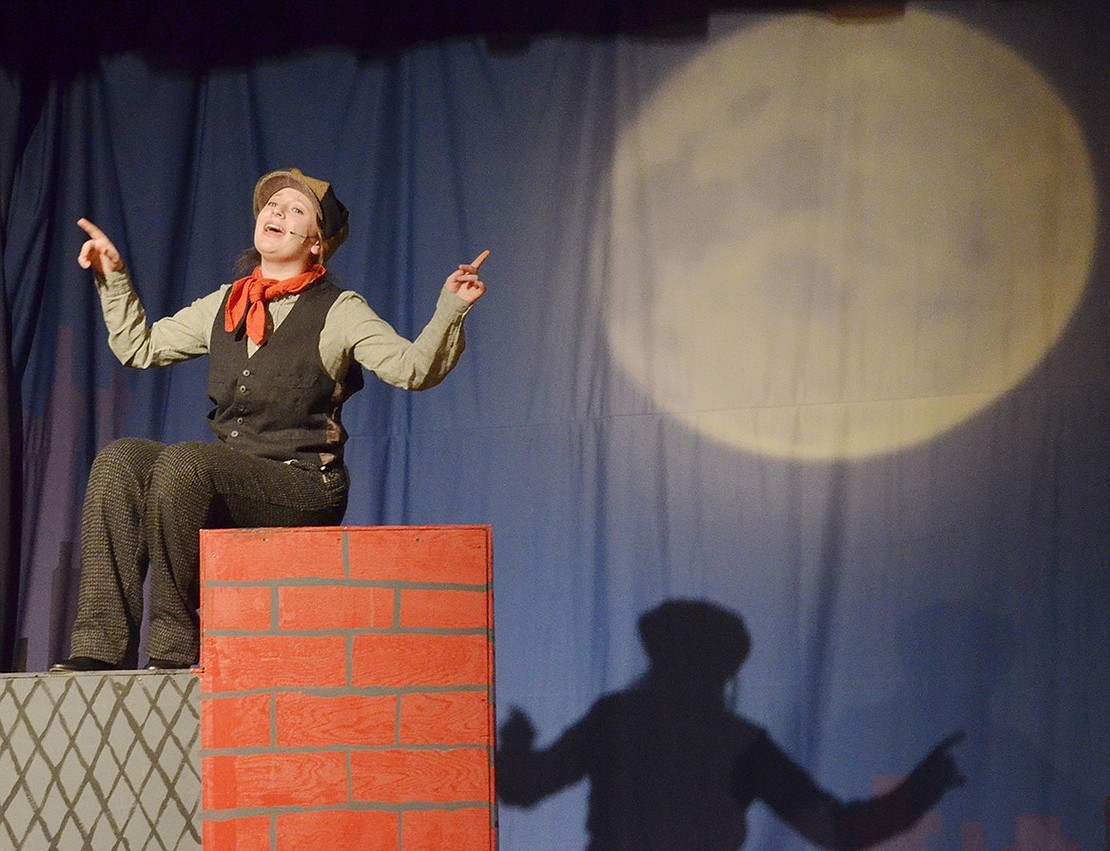 Bert the Chimney Sweep, played by Sophia Ortiz-Heaney, sits on a roof and enjoys the views of London while singing about the charm of his life during “Chim Chim Cher-ee” under the moonlight.