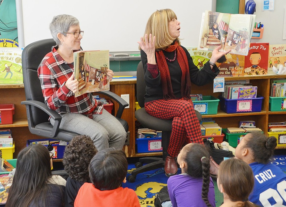 Children’s book author Roni Schotter (right) animatedly reads her story “Nothing Ever Happens on 90th Street” while LitWorld board member Lauren Blum holds up the book for a visual backup on Friday, Feb. 1. They’re reading out loud to John F. Kennedy Elementary School teacher Cheryle Washington’s third-grade classroom for World Read Aloud Day, a global event spurred by LitWorld to advocate for literacy as a human right.