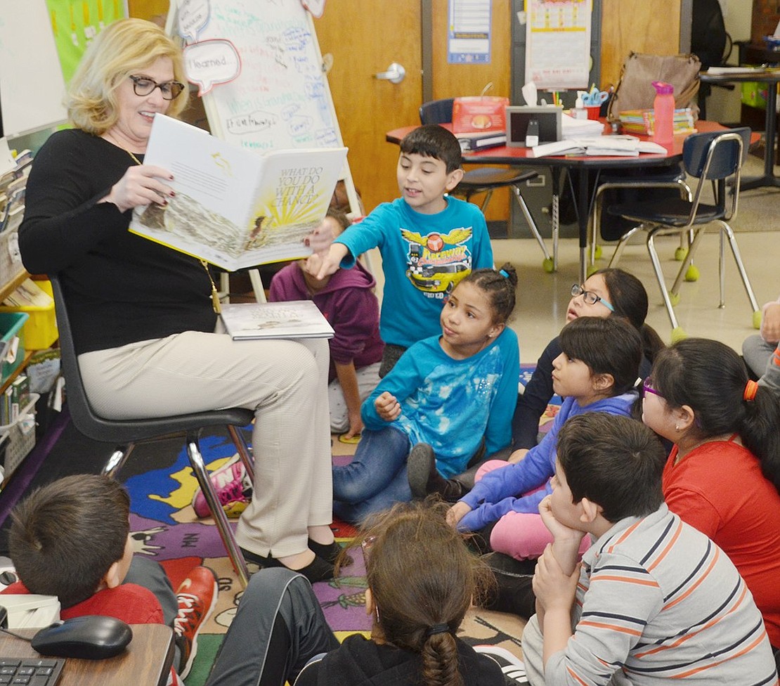 Sherrie Dulworth, a member of the LitWorld advisory council, engages third-graders in Melissa Coletti’s class as she reads “What Do You Do with a Chance” to them. Throughout the day, volunteers from the district, Village of Port Chester and greater community visited every classroom for a 30-minute reading session.