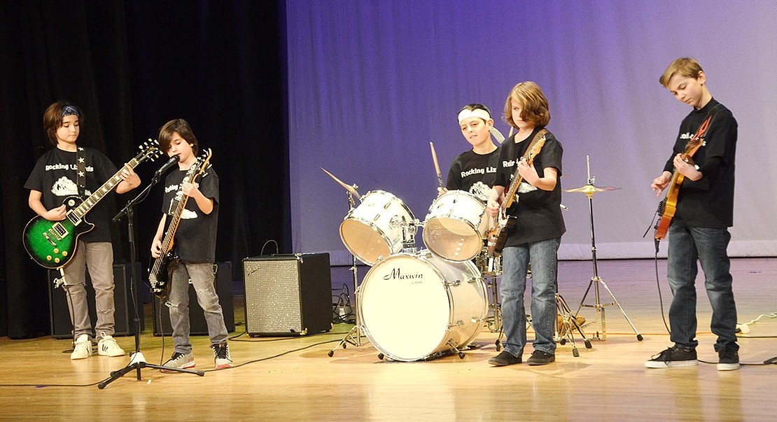 Talent show or rock concert? Hard to tell once the Rockin’ Lizards take to the stage to jam out to “Summer of 69” by Bryan Adams. From the left: fifth-grader Juan Anton, fourth-grader Jorge Anton, Harrison sixth-grader Ollie Schenk, fifth-grader John Thorn and sixth-grader Grant Klein.