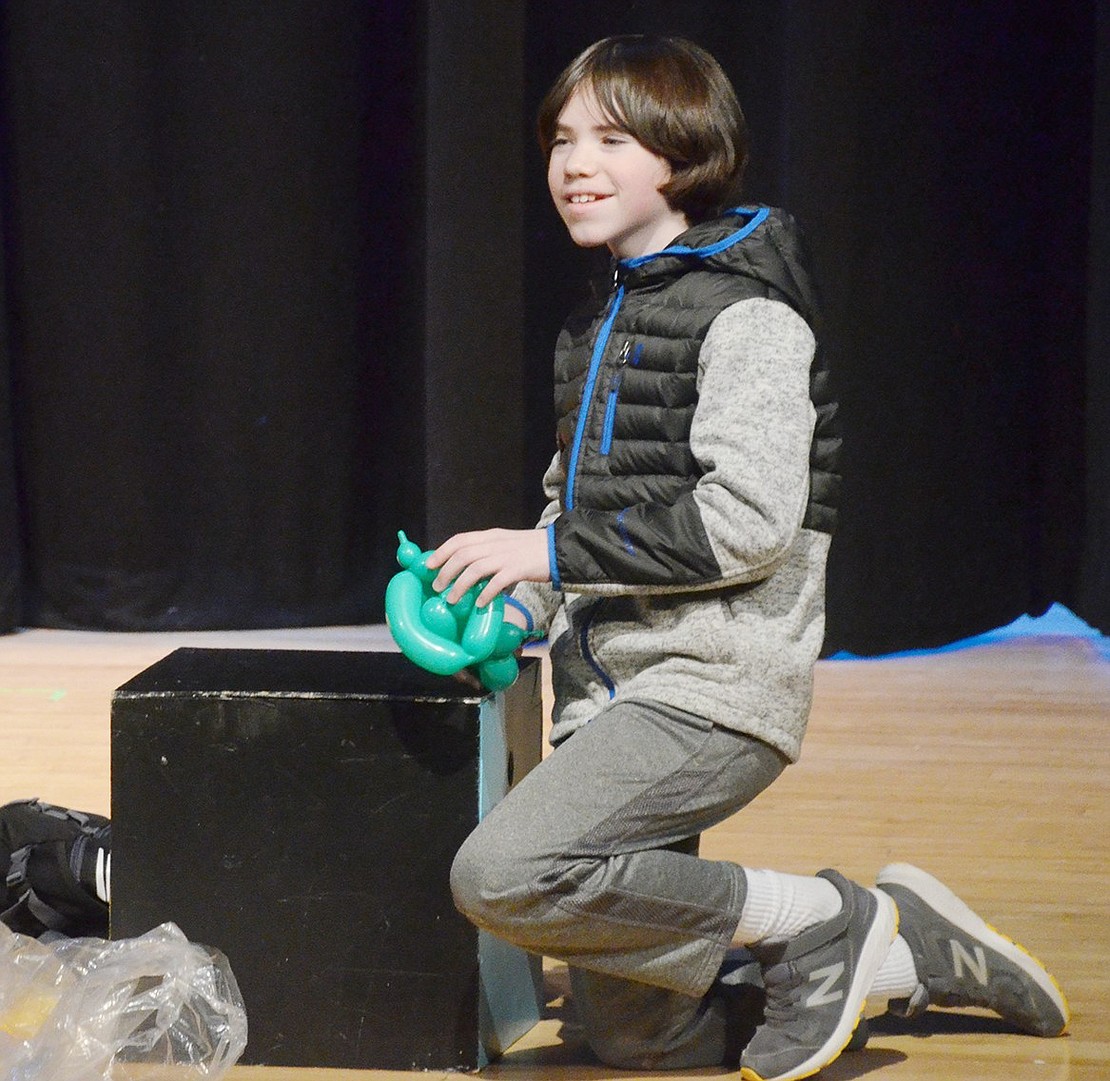 Displaying some crafting skills, seventh-grader Jackson Welde makes balloon animals for audience members who can answer Blind Brook trivia questions correctly.