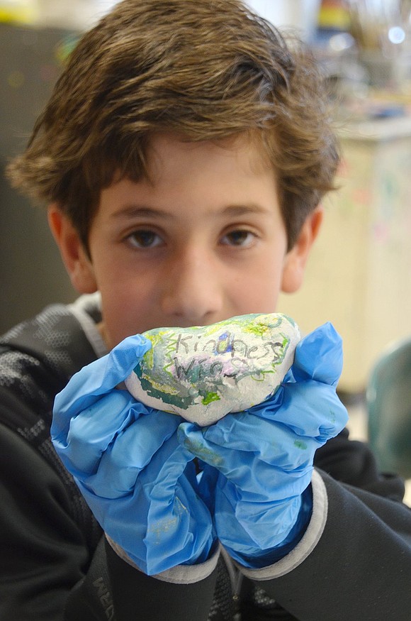 After gushing in pride over his green and blue masterpiece, Rex Kanner shows off his rock marked with the words “kindness wins” on Monday, Mar. 11. The Ridge Street Elementary School third-grader is celebrating #MakeArtMonday in art teacher Betsy Murphy’s class with a school-wide “Kindness Rock” project where students decorate stones with compassionate words and phrases.