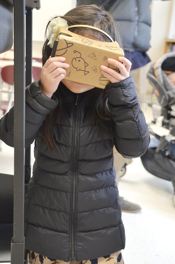 James Way resident Sophia Guh takes a trip to the Great Wall of China with a student-made cardboard virtual reality device. “I’m in China,” the 4-year-old exclaims as she walks around the room.