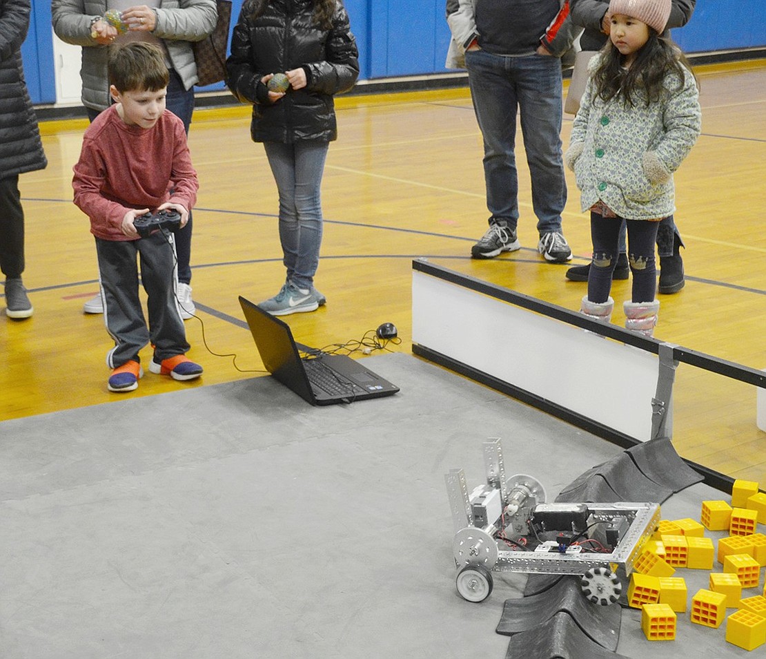 In the gymnasium where the Blind Brook High School Jellyfish robotics team does demonstrations, Ridge Street Elementary School first-grader Noah Lupow eagerly tries to steer a robot over a barrier.