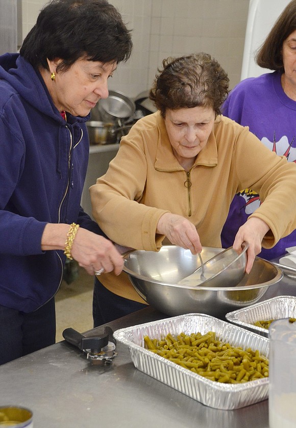Tucked away in the kitchen, Rye Brook resident Rhoda Shapiro (left) and Port Chester resident Helene Simon pour mushroom soup into a bowl for a green bean casserole dish to be delivered to the St. Peter’s Soup Kitchen in Port Chester.