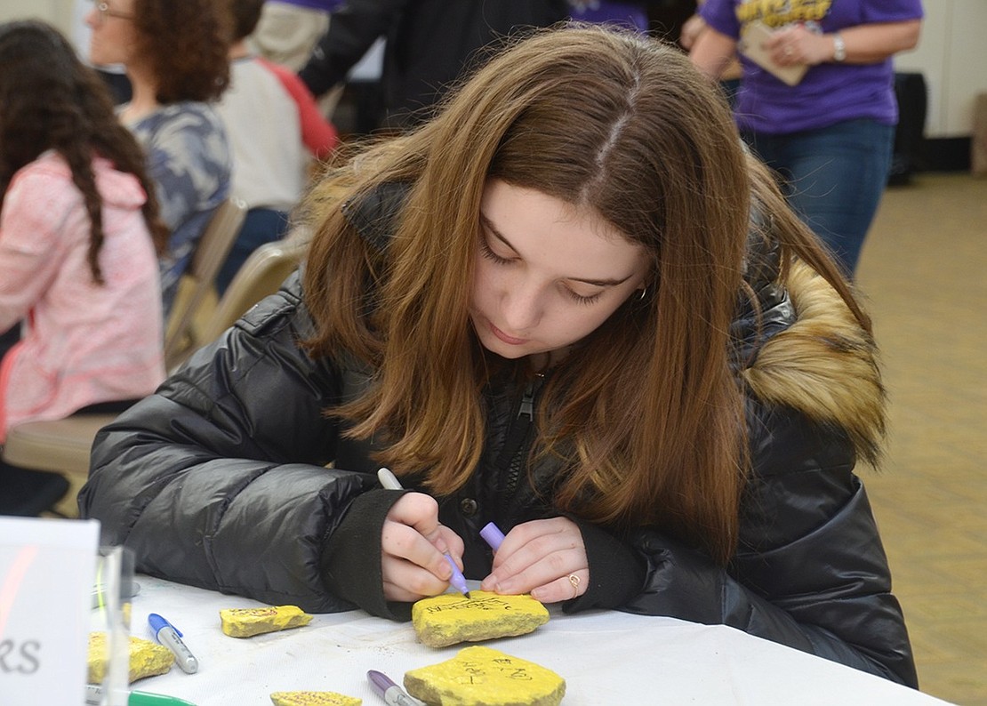 “Smile Every Day,” Blind Brook Middle School sixth-grader Madilyn Klein writes on a stone at the Kindness Rocks table. The rocks adorned with encouraging messages will be randomly spread throughout the Rye Brook area.