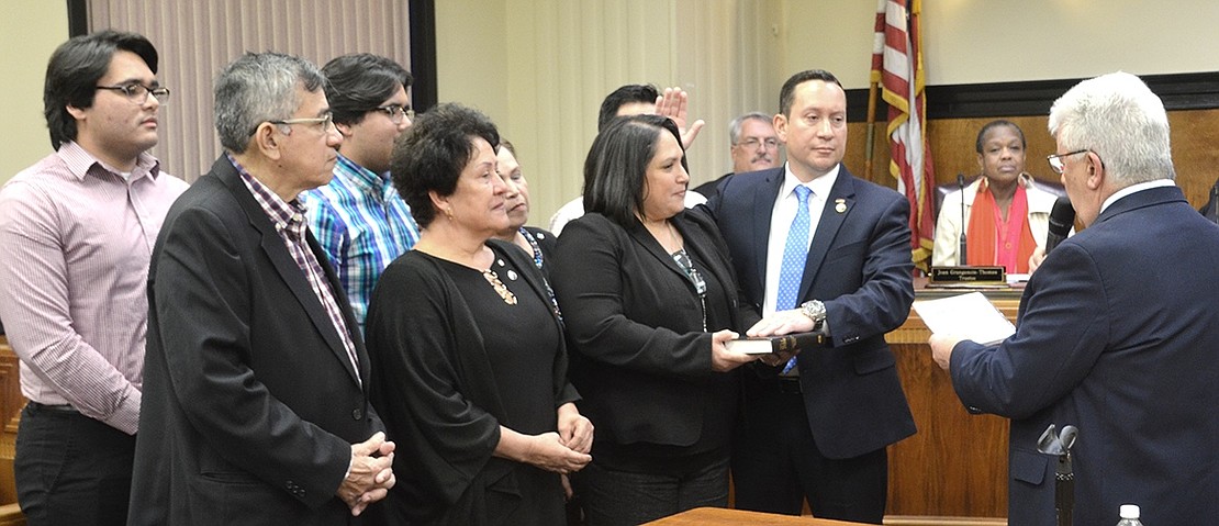 Alex Payan is sworn in Tuesday night as a brand-new Port Chester trustee by Mayor Richard “Fritz” Falanka. He is accompanied by his wife Marianela holding the Bible and other family members.