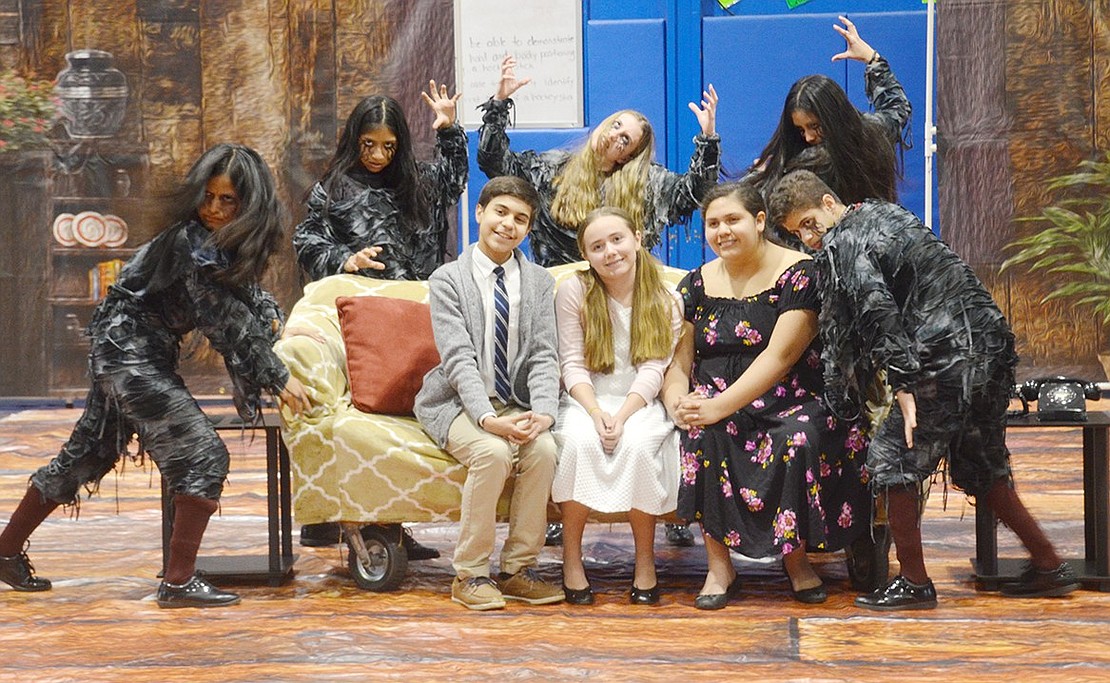 Unaware that they’re surrounded by evil spirits, Port Chester High School freshman Ivan Lopez (left), middle school eighth-grader Elia Mateus and freshman Gaby Flores look like a happy family before the haunting begins. The PCHS Marching Band Winter Percussion members are performing the horror movie-based MAC championship winning show “The Uninvited” during the Night of Indoor Pageantry in the Port Chester Middle School Gym on Wednesday, Apr. 10.