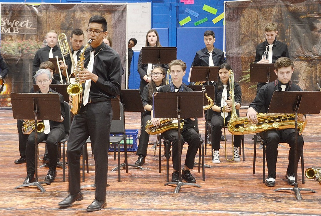 Senior Mario Flores fervently executes a solo on the saxophone during the jazz band performance.