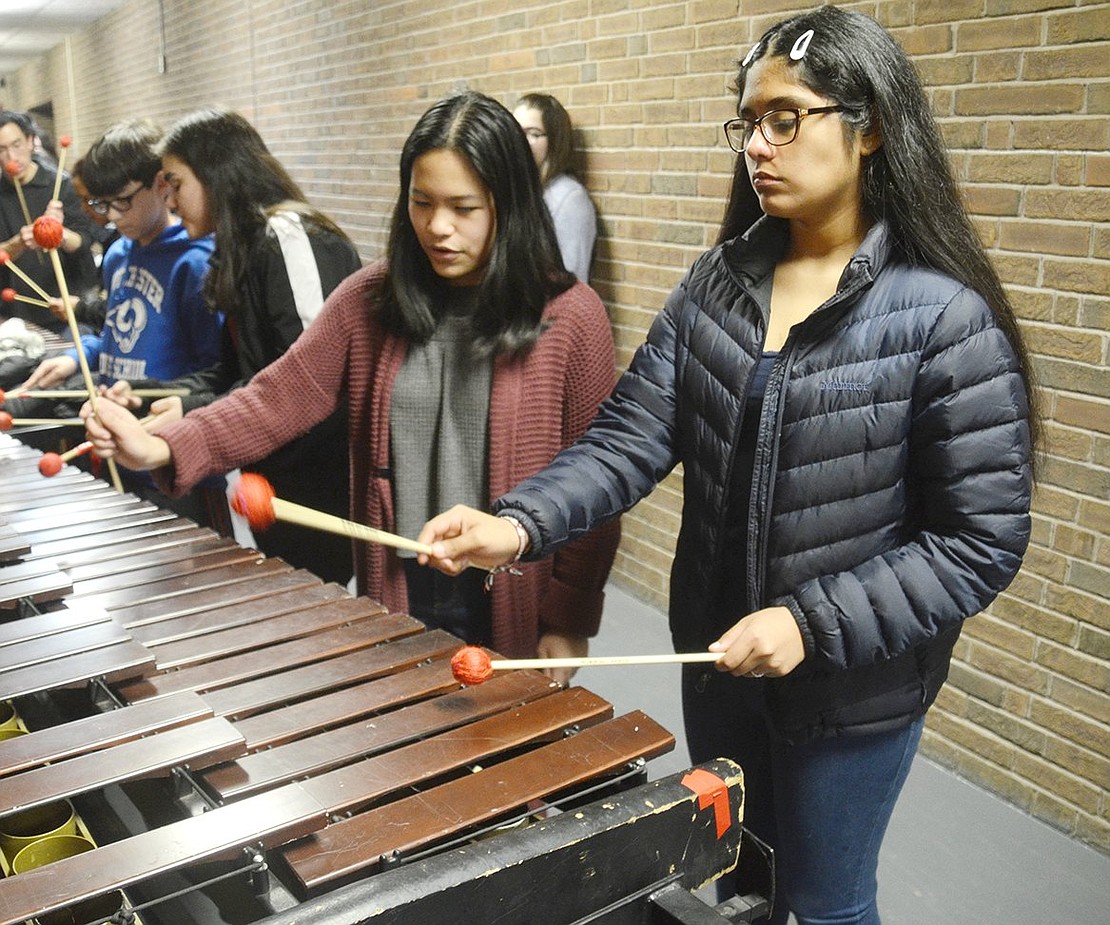 Junior Linsey Co (left) teaches middle school eighth-grader Juliana Lopez a few scales on the xylophone, while encouraging her about being a natural. After the showcase, band members hosted clinics for other students interested in learning more about music.